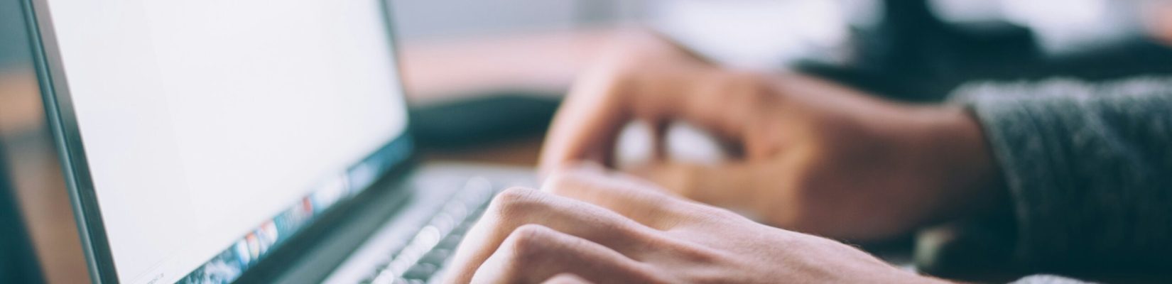 Person working on a laptop, hands visible only